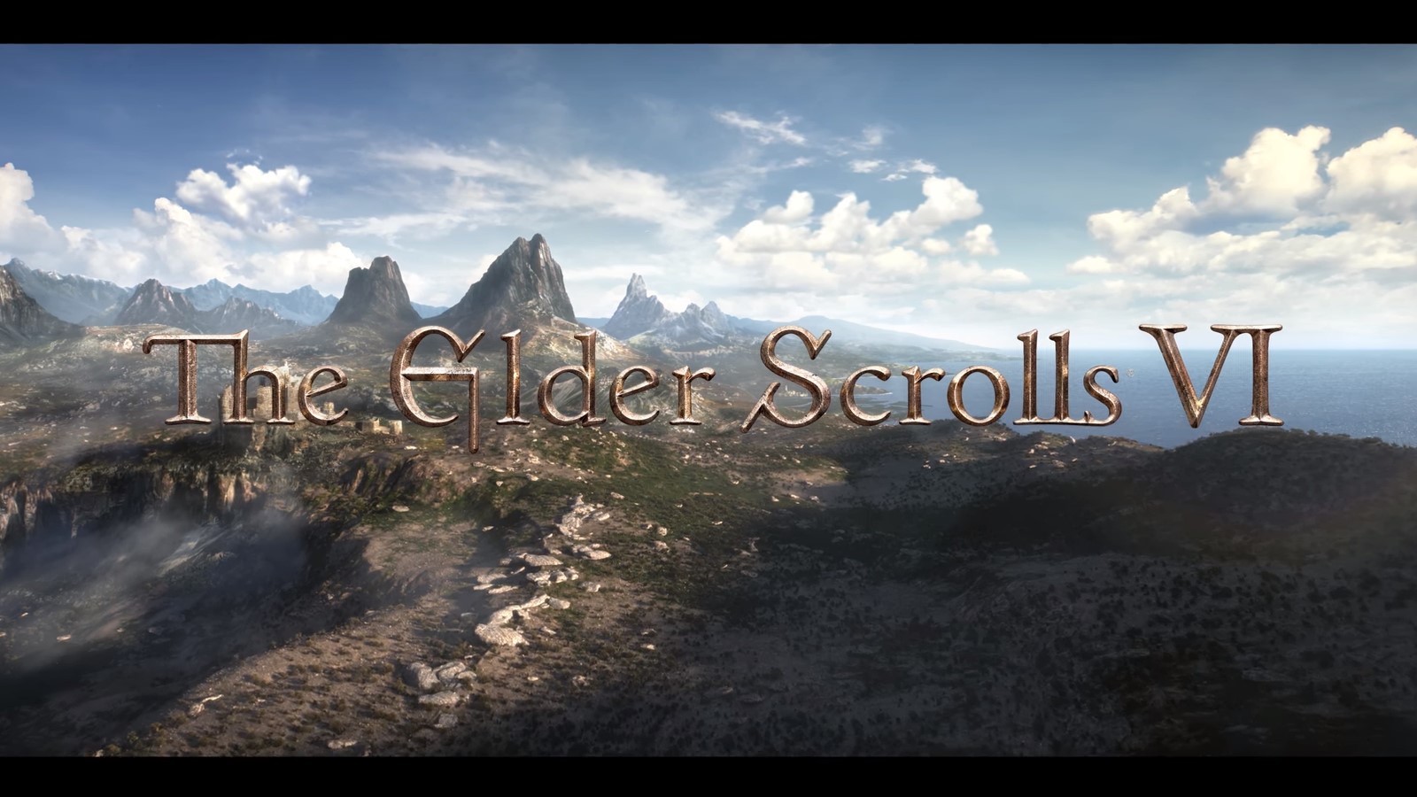 the elder scrolls logo on top of a coastal mountain range