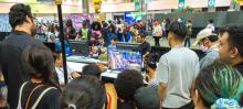 A bunch of gamers watch a fighting game in progress