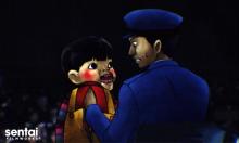 This screencap shows a police officer with a very creepy puppet.