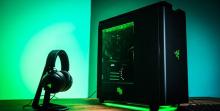 Clean green Razer gaming build and headset on stand.