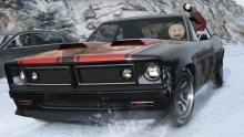 A muscle car driving through the snow with a driver wearing a gingerbread man mask throwing a snowball.