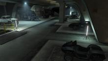 A nice view of an empty area of a bunker filled with custom vehicles.